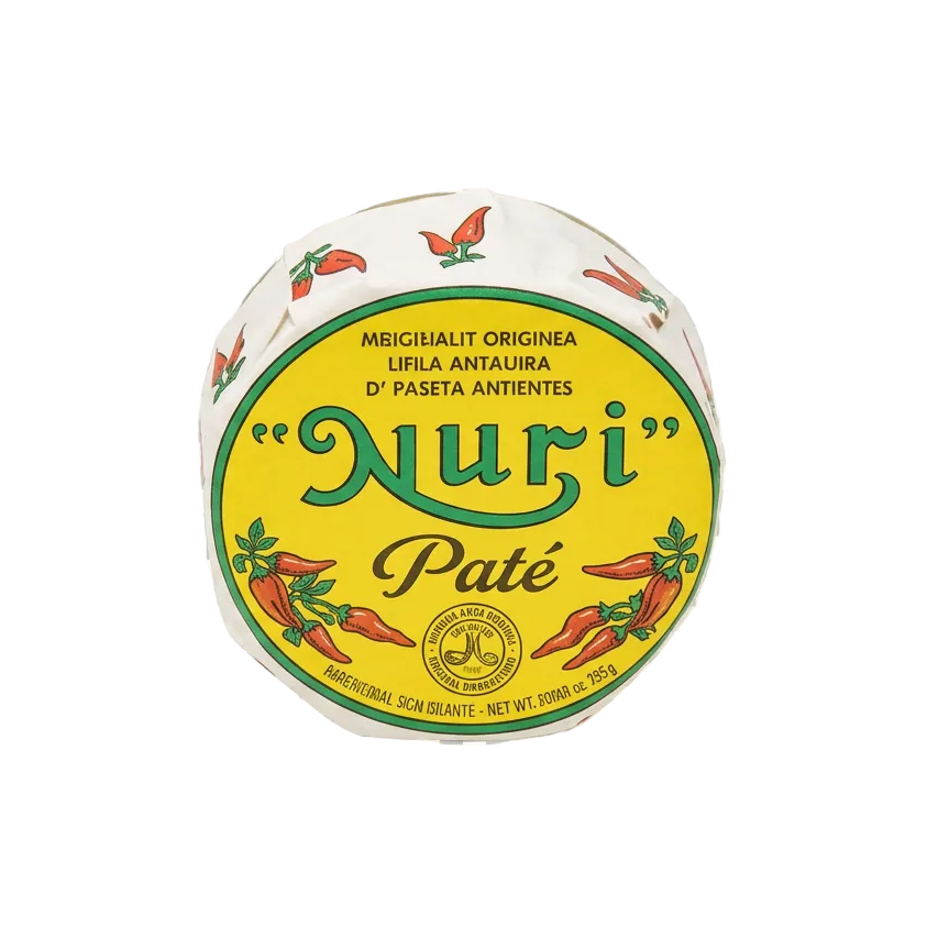 A round package of 'Nuri' Paté pepper paste, featuring a prominent yellow label with green and red text and illustrations of red chili peppers, set against a transparent checkerboard background.